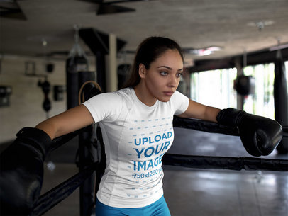 Sports Mockup of a Tired Woman Wearing Custom Sportswear While Resting Against Ring Ropes After Sparring