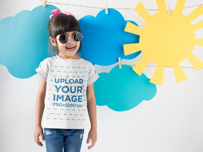 Smiling Girl Wearing a Round Neck Tshirt Template Near Cardboard Sun and Clouds